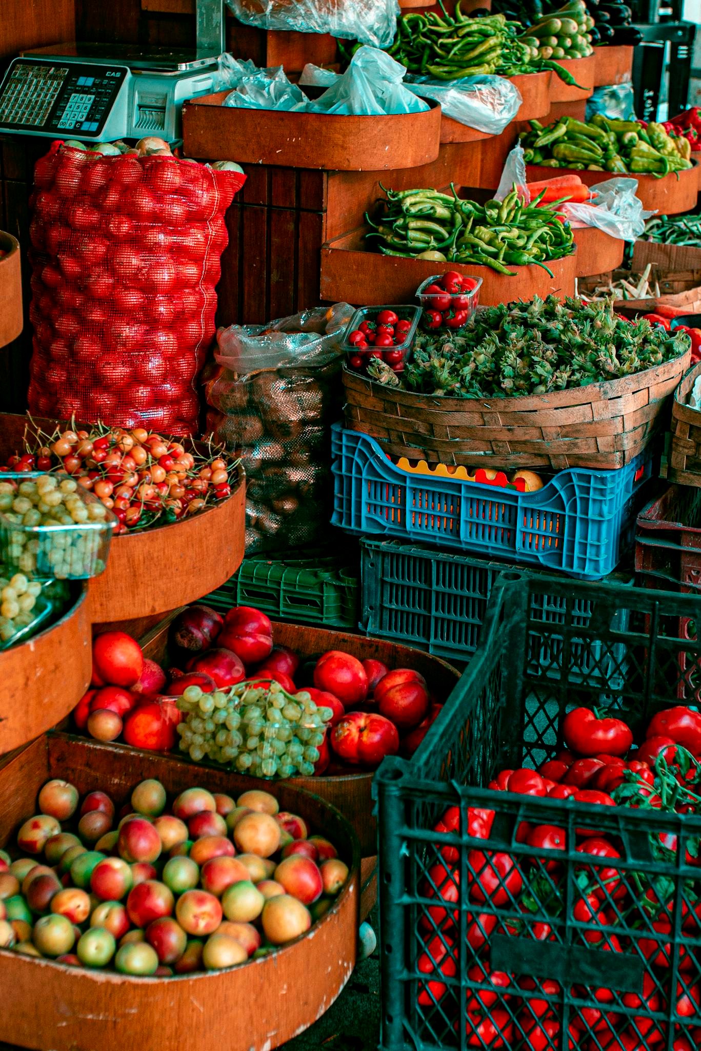 A colorful display of fresh fruits and vegetables at a bustling open-air market.