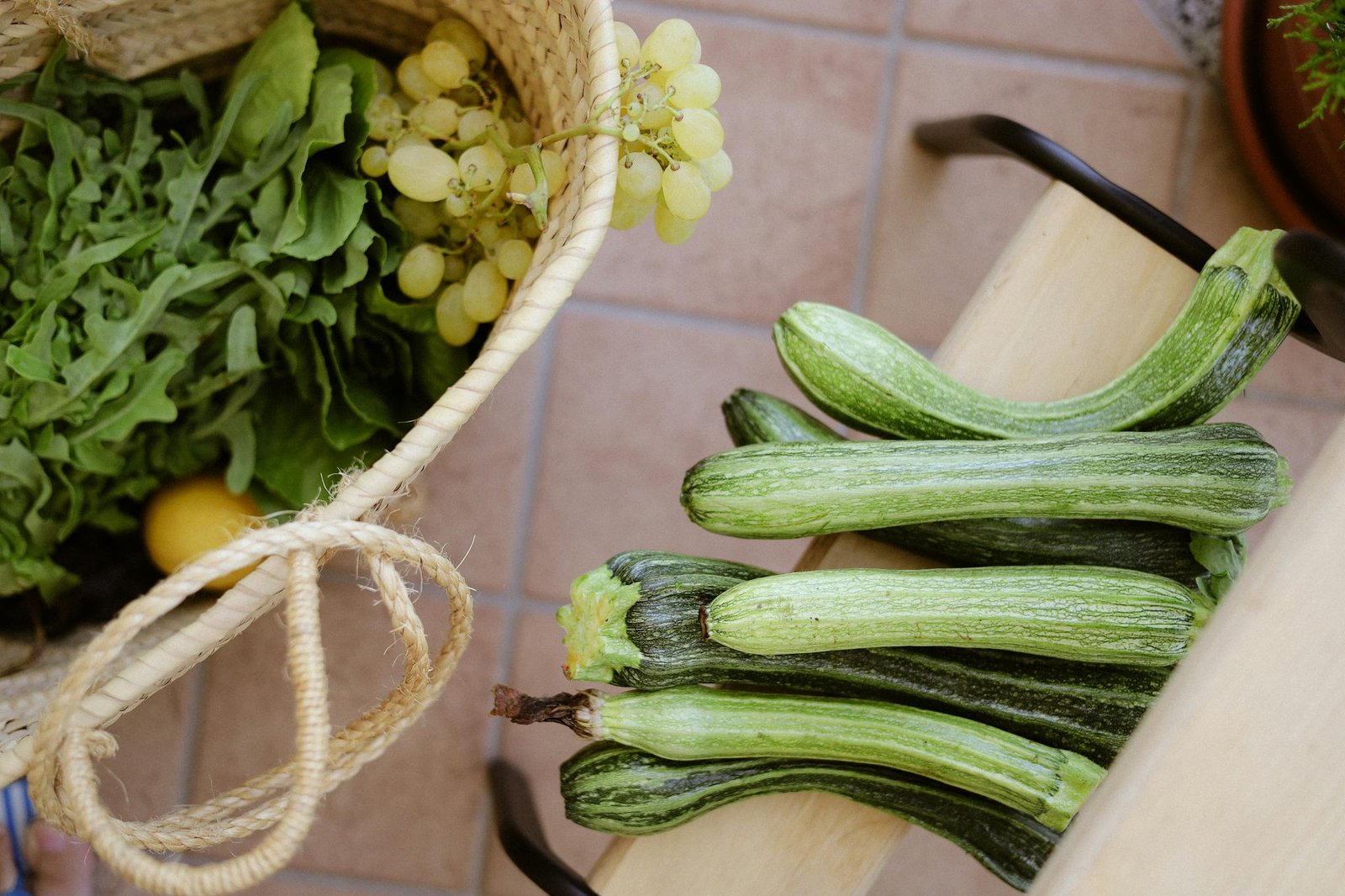 Top view of fresh zucchini and greens in basket, ideal for organic lifestyle stock photos.