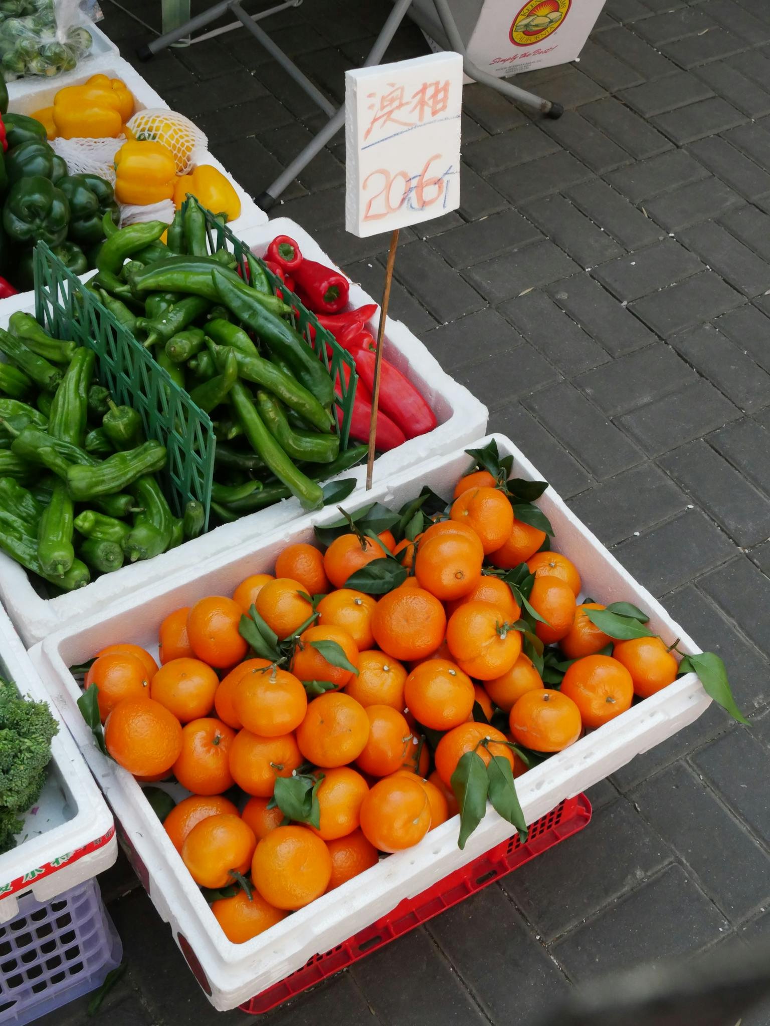 Fresh tangerines displayed at a market stand in Hong Kong. High-angle view shows vibrant produce.